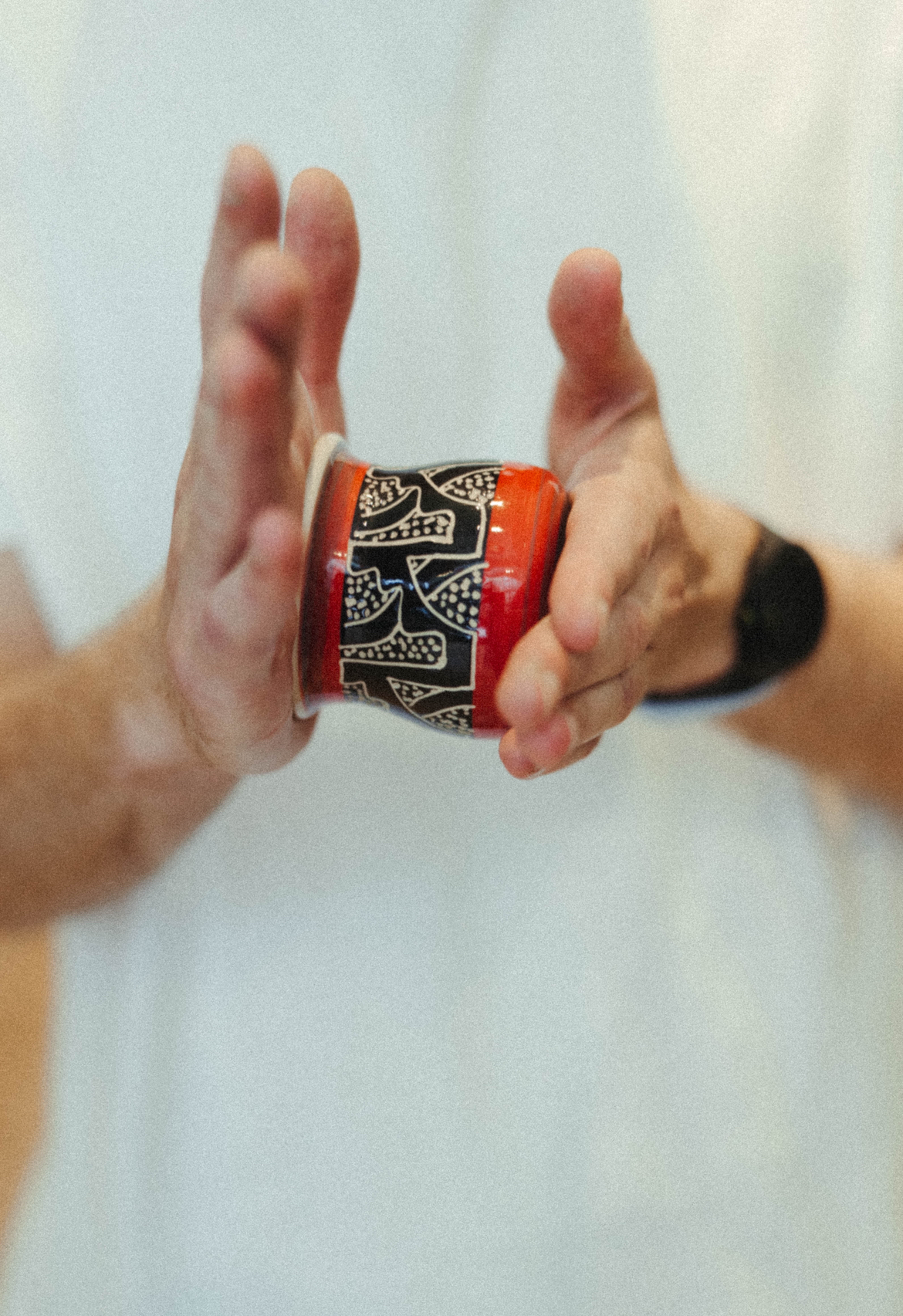 Hand-painted mate held up between two hands.